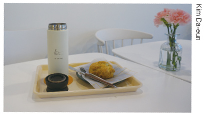 The UOS Times Reusable Cup and a Scone on a Piece of Biodegradable Paper Napkin
